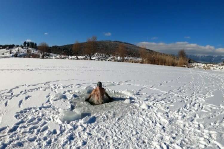 Bursalı dağcı üzerinde yürüdüğü buz tutan göleti testere ile kesip içinde yüzüyor