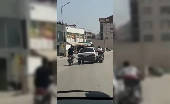 Bursa'da motosiklet sürücüleri yolda kalan otomobili ayaklarıyla ittiler